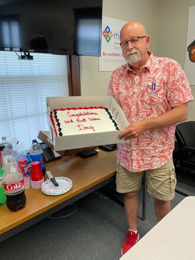 Mr. Lambert with his retirement cake from the central office. 